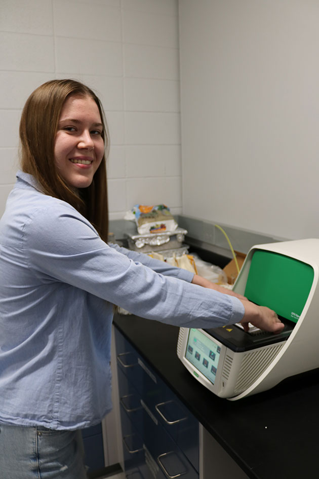 Alex Rachynska uses a QPCR machine that amplifies and detects DNA.