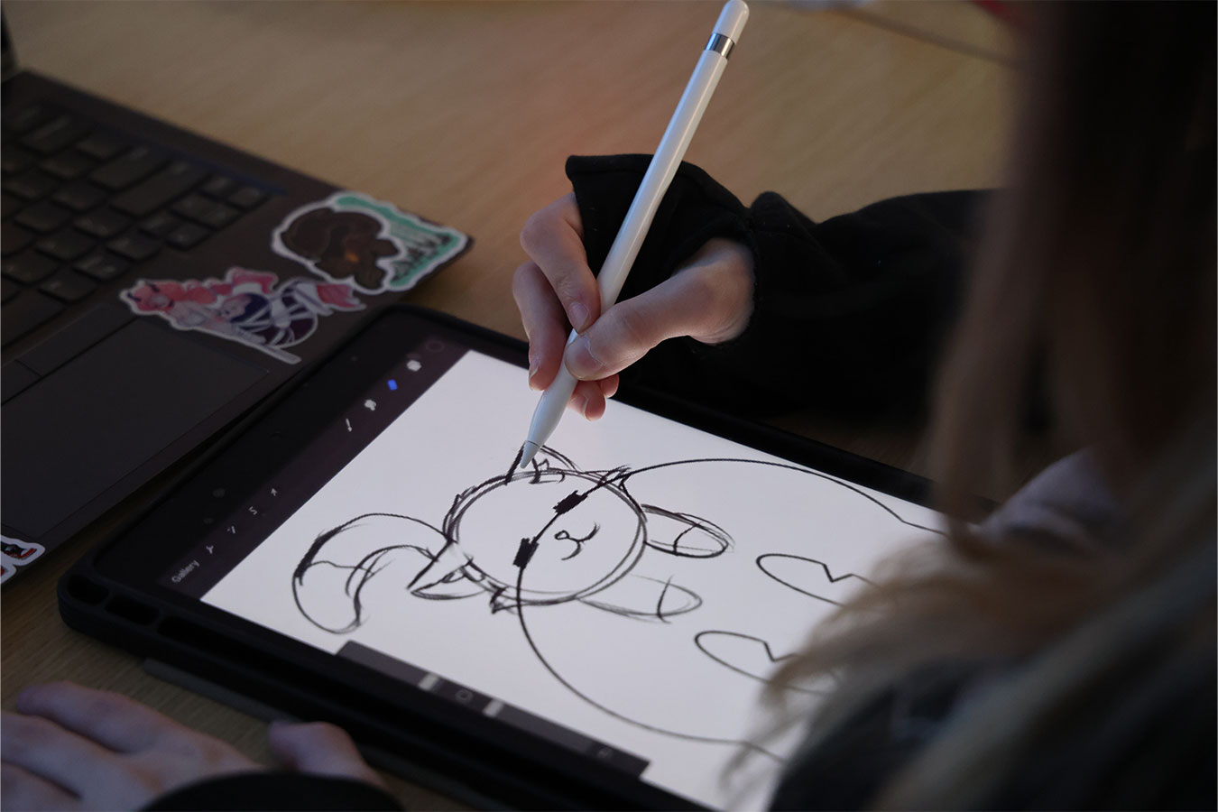 Game design student drawing a cat on a tablet.
