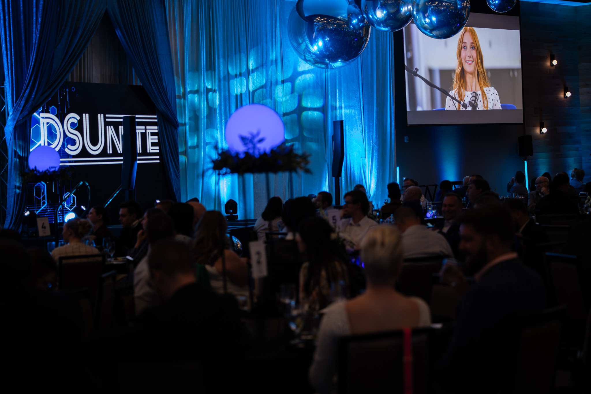 DSUnite event setting with DSUnite written on left side and video showing Paige Phinney on right