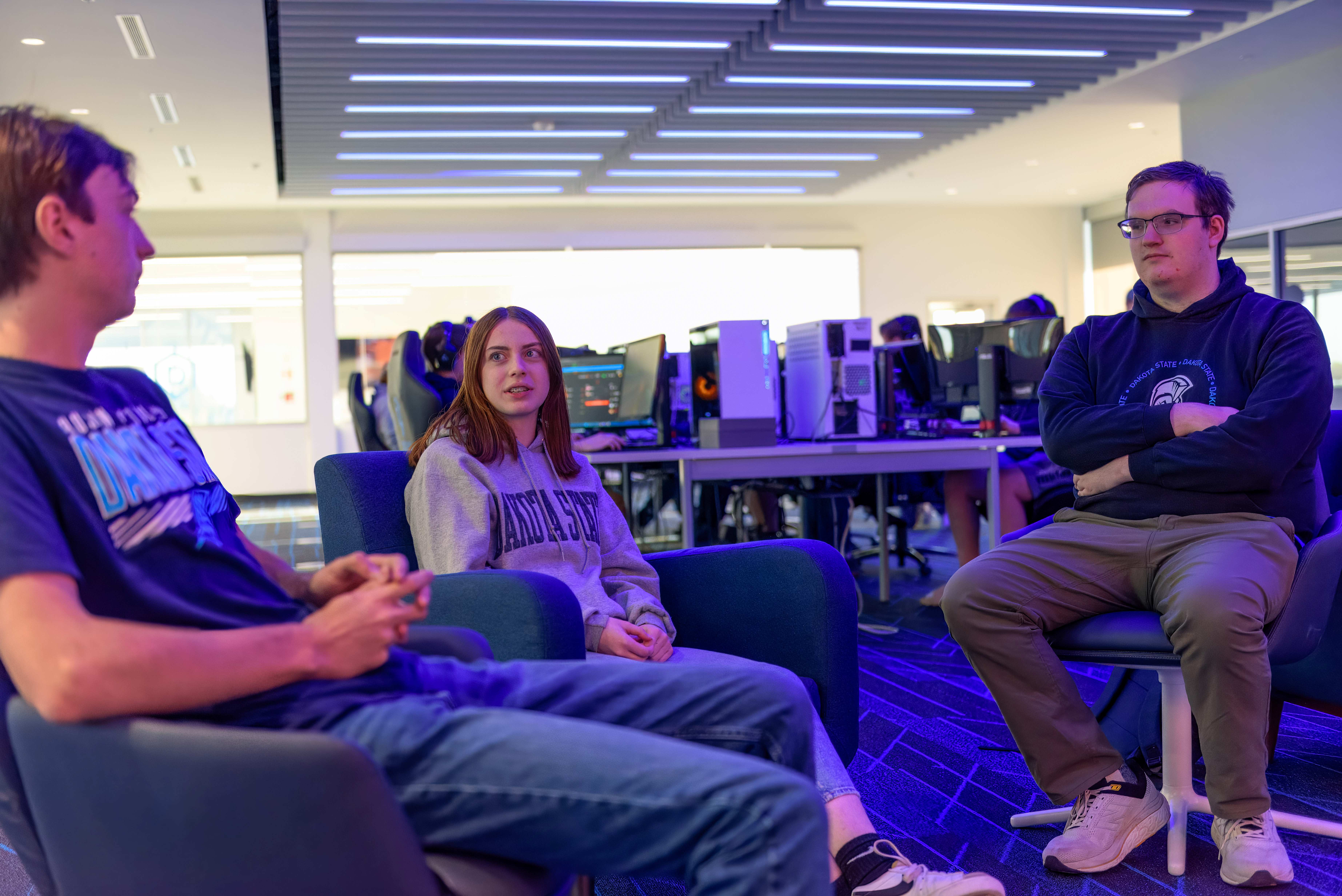Three DSU students talk in the DSU Esports Arena.