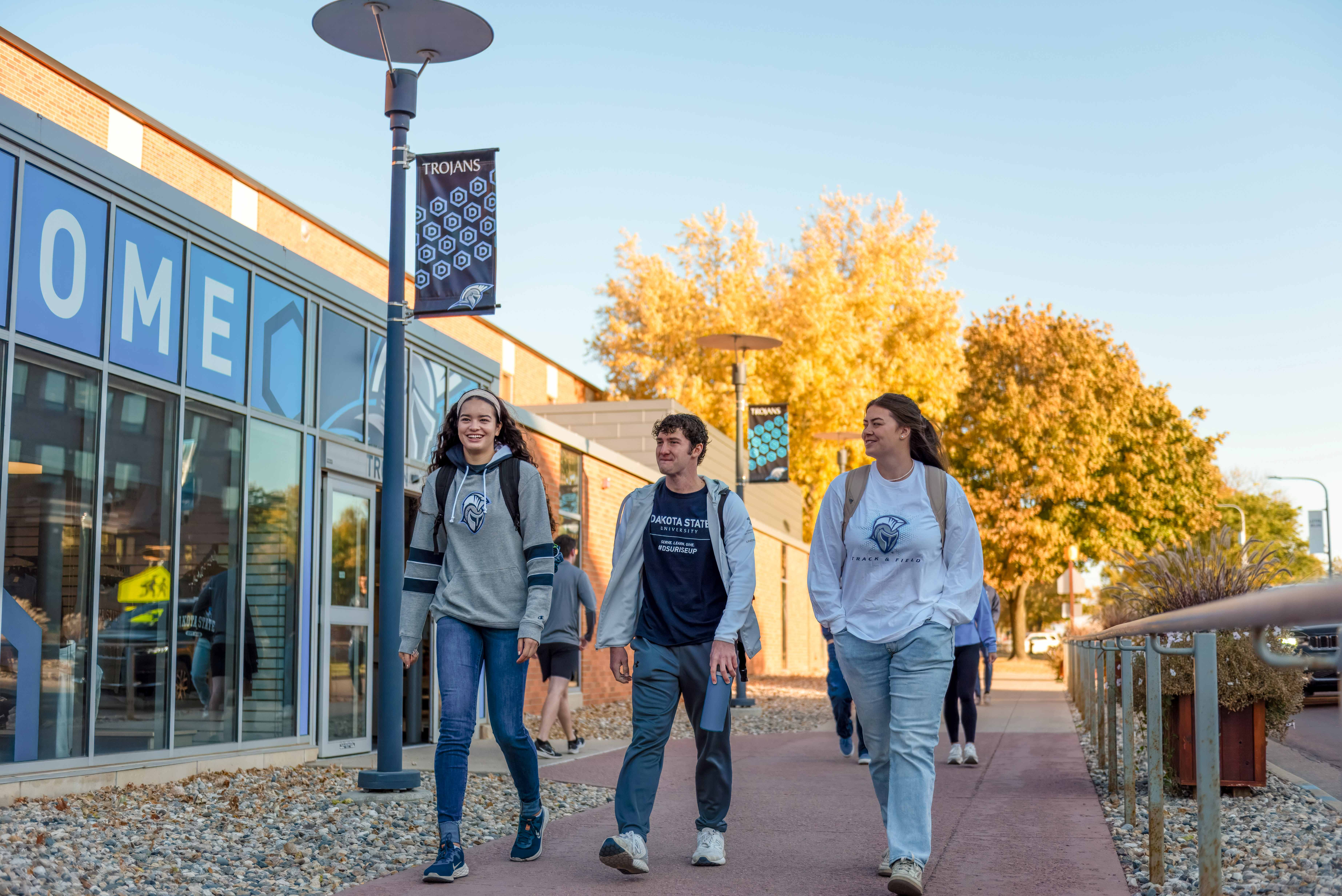 Three DSU students walk in front of the TrojanZone.