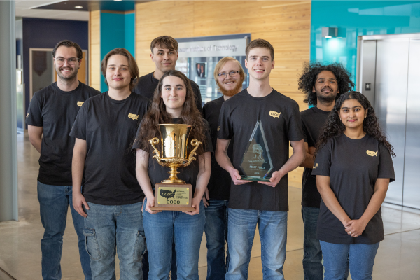 Members of the NCCDC National Championship team standing with the trophy in Beacom Institute of Technology