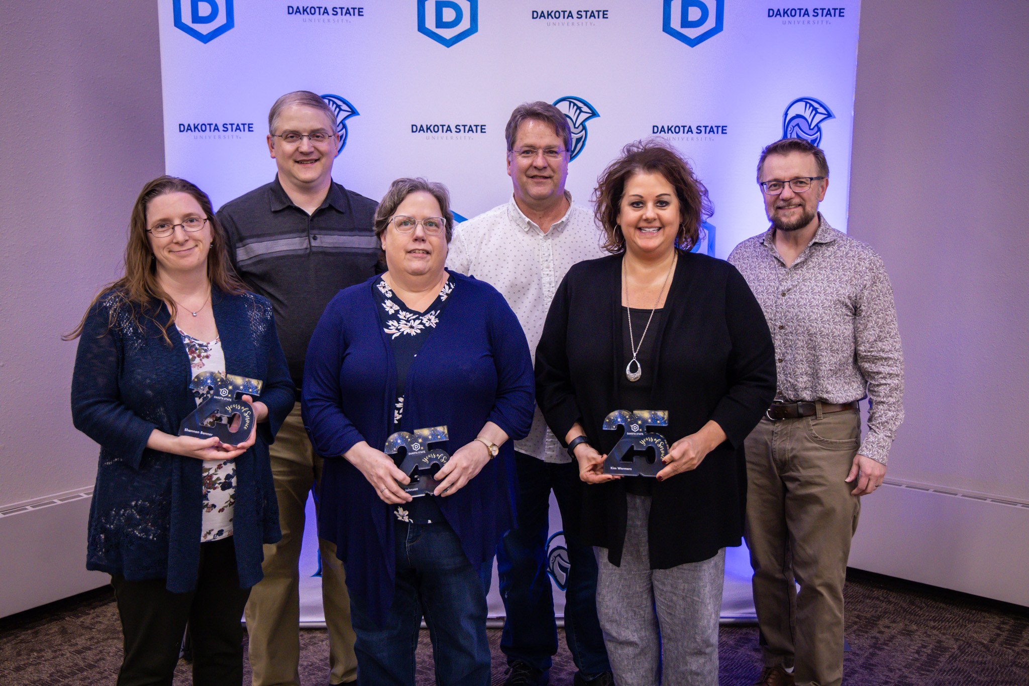 Shannon Bonner, John Bonner, Marie Johnson, Thomas Jones, Kim Wermers, Justin Blessinger in front of DSU backdrop
