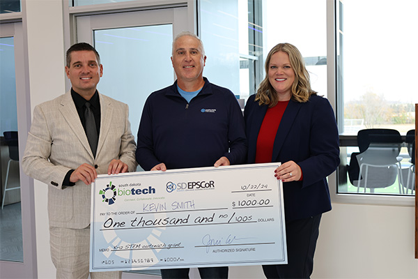 Dean David De Jong, Dr. Kevin Smith, and Dr. Ashley Podhradsky take a photo celebrating Smith's grant.