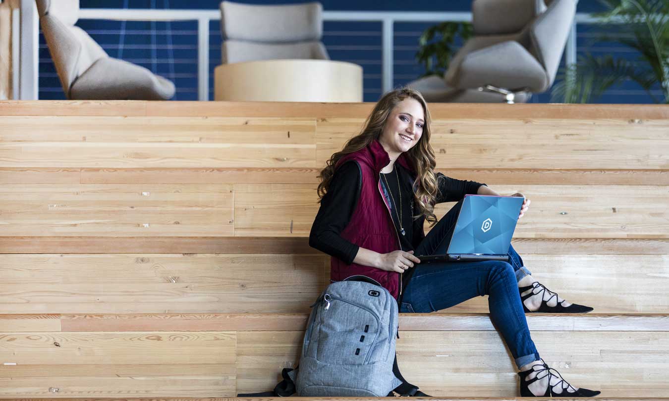 DSU student sitting in The Beacom College of Computer & Cyber Sciences building