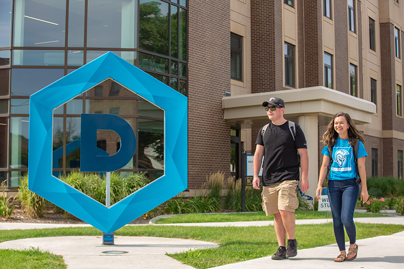 Students Walking On Campus by the large Hex D