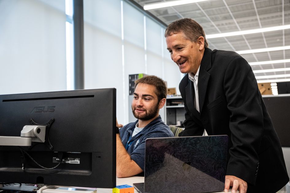 student and professor looking at computer in madlabs
