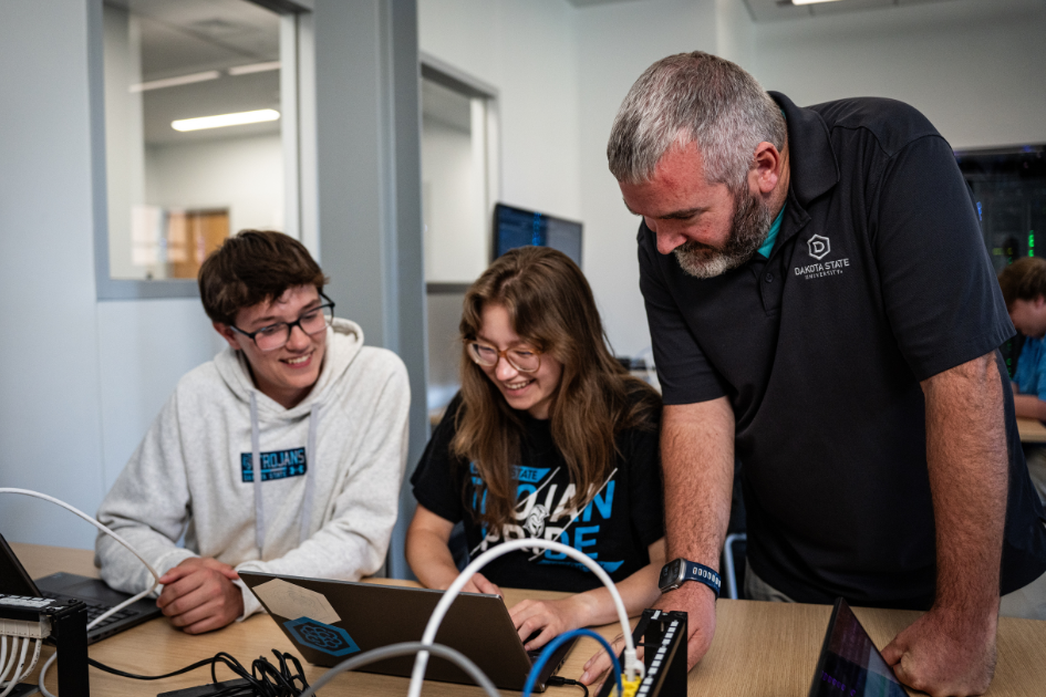 Cyber Defense Masters students in class with professor
