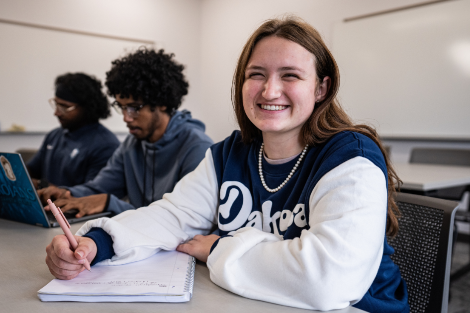 student smiling at camera in class