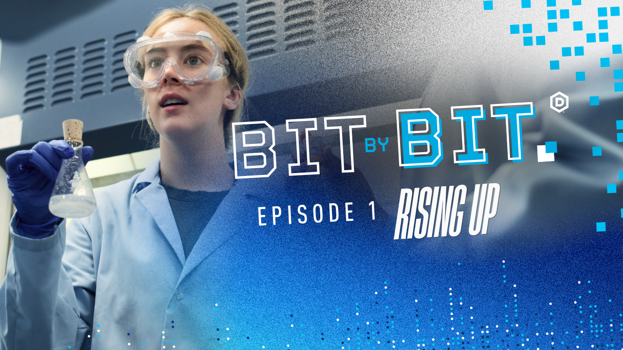 A DSU student holding a flask full of liquid in a lab coat. The text on the video thumbnail reads Bit by Bit episode oen.