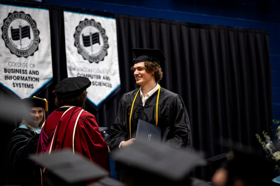 dsu student walking across stage at commencement