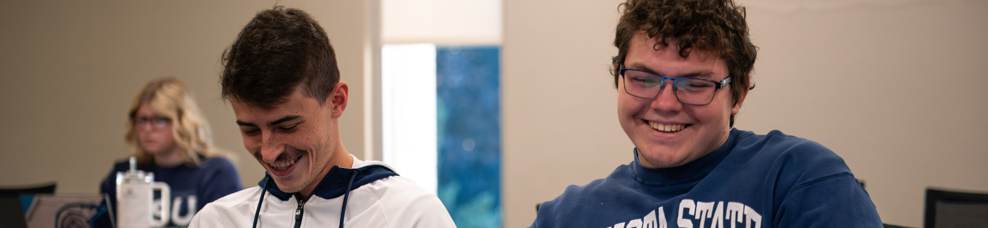 two students smiling and laughing in class
