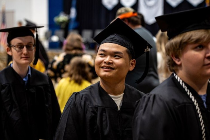 dsu student with cap and gown at graduation smiling