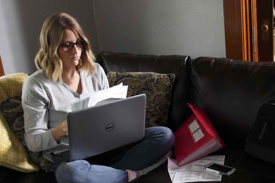 Student at home with computer and homework