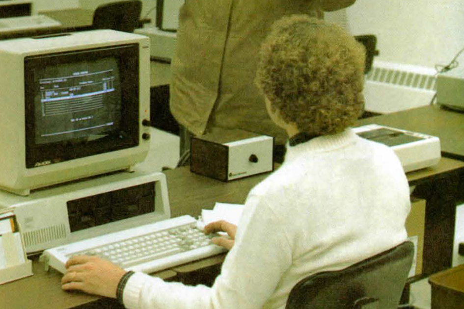 old photo of student working on original campus computer