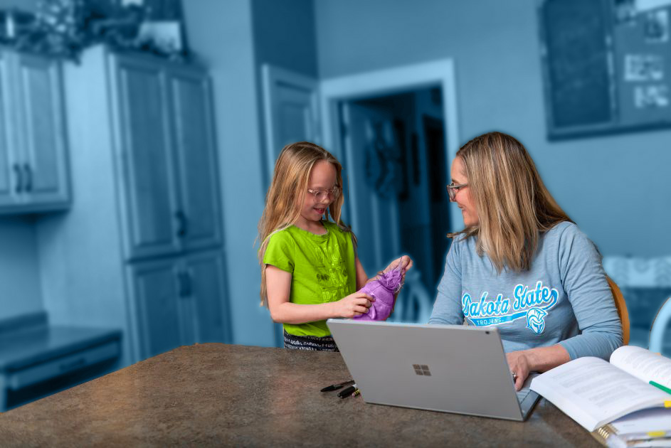 Student at home with computer and child