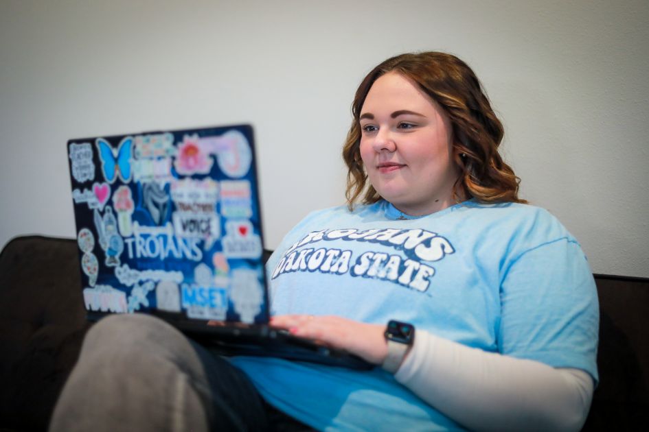 dsu online student working on laptop at home on couch
