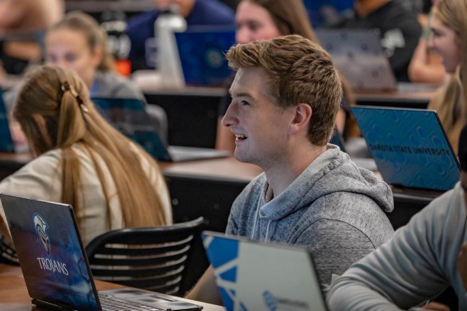 dsu student in large class with computer and smiling