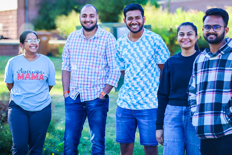 International students on the lawn smiling, enjoying their time at Dakota State University.