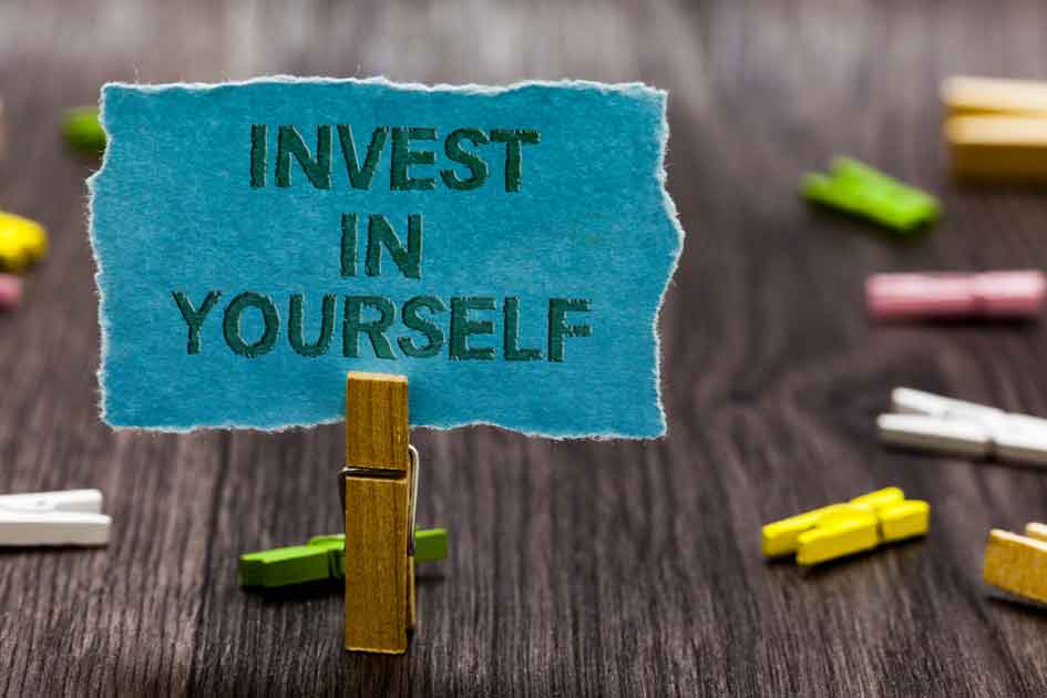 Invest in yourself reminder note held by a close pin