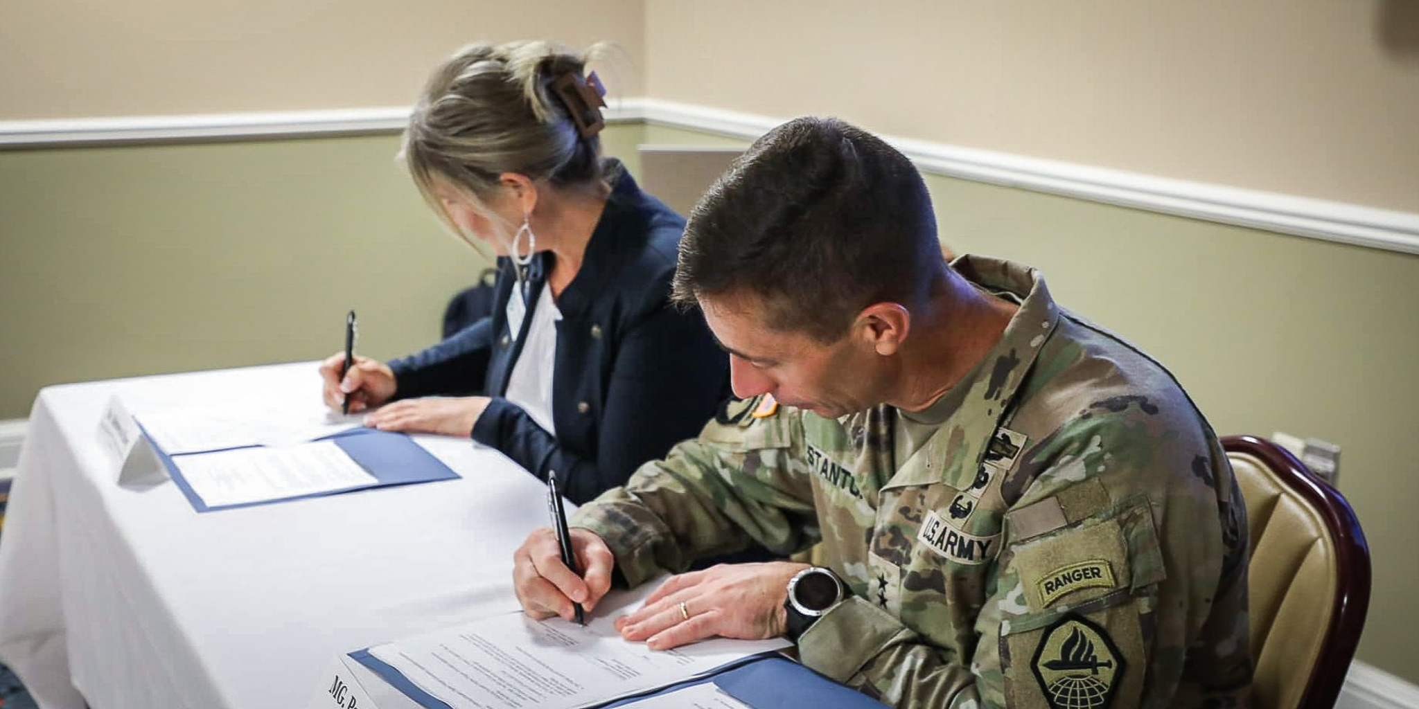 Dr. Rebecca Hoey with soldier signing articulation agreement papers