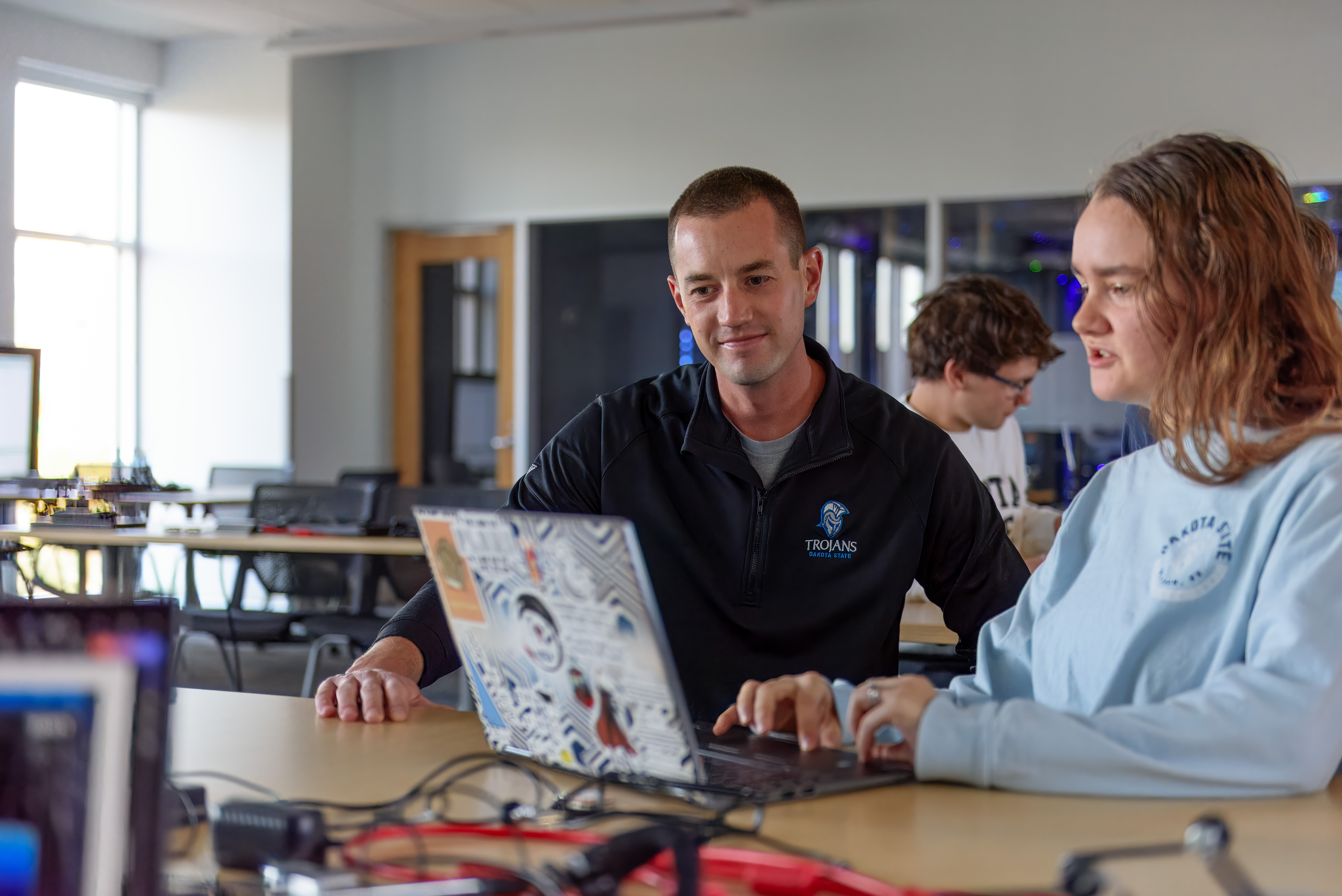 DSU student and DSU professor looking at classwork on computer in classroom.