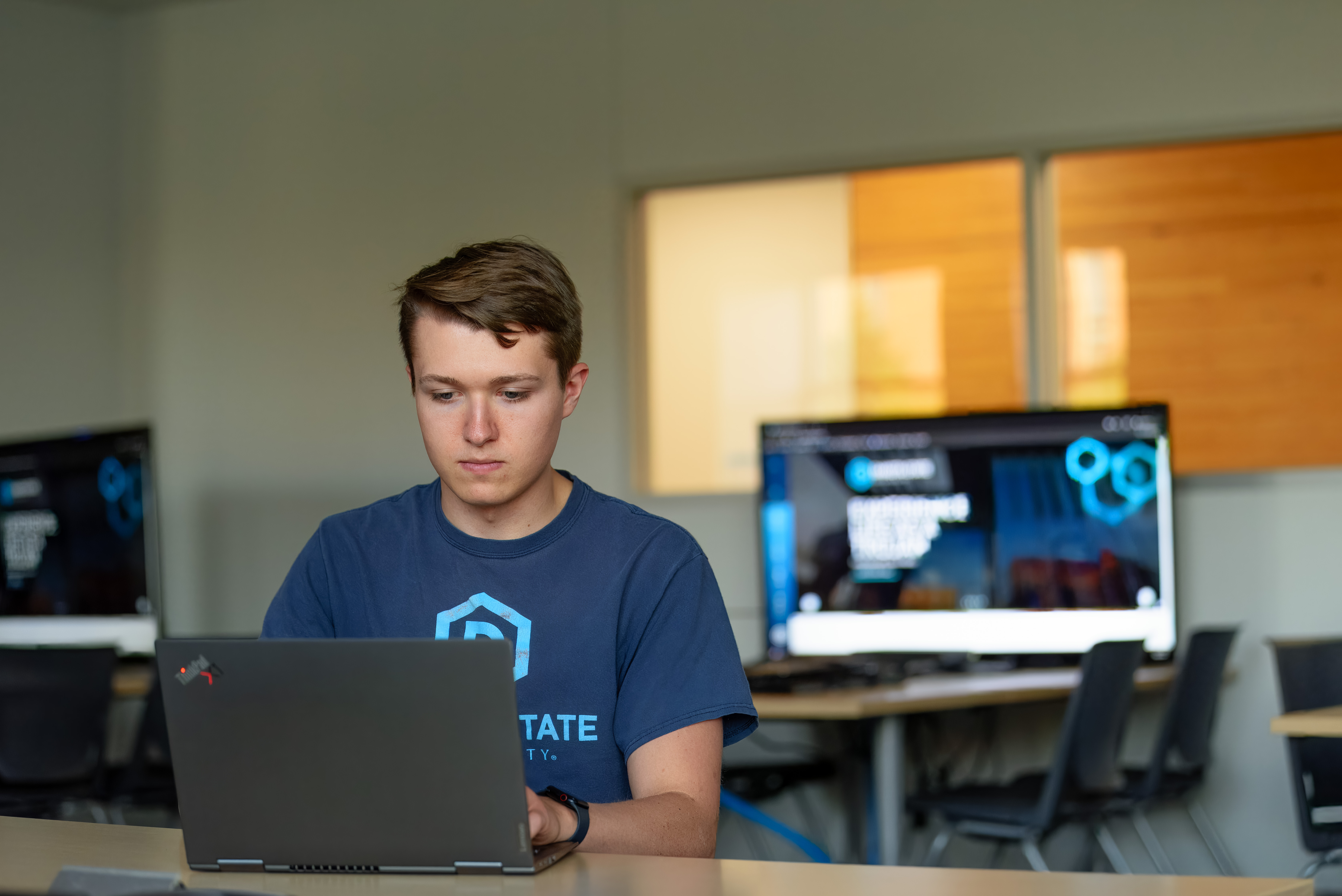 DSU student working on computer in classroom.
