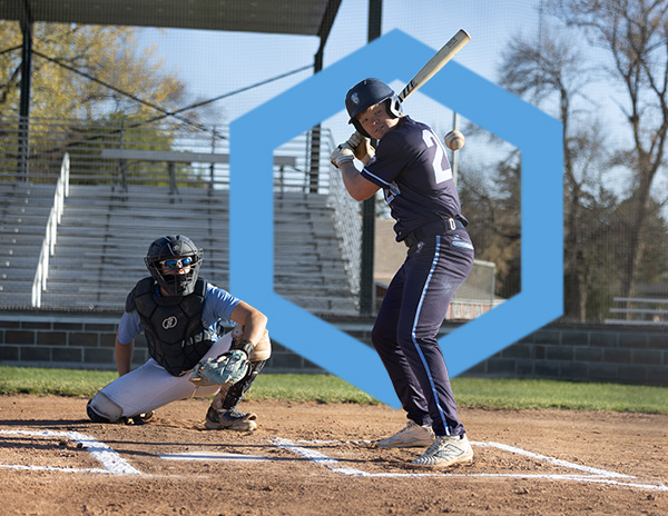 A batter standing at home plate as a baseball approaches.