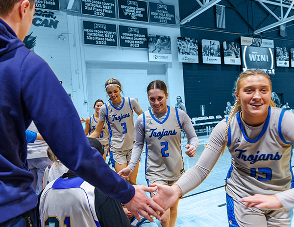 Trojan baskeball team forming a line to shake hands. 