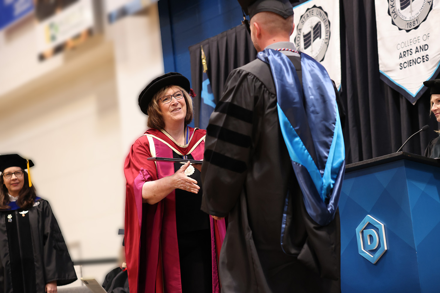 Dakota State University President Griffiths shaking hands with a graduate