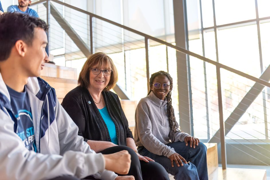 President with students on stairs in Beacom