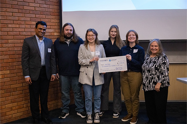 The team Normalized Pulsars earned first place, winning $2,500. Here they pose with their oversized check and Dean Bennett.