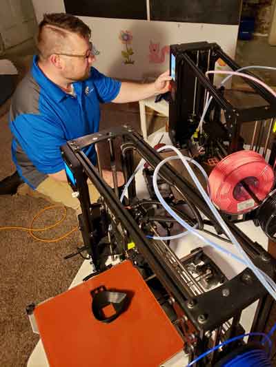 Dr. Justin Blessinger works with a 3D printer to create devices for users of powered chairs and scooter, making power more accessible. Commercialization and technology transfer of the device is being funded through an i6 Biosciences grant.