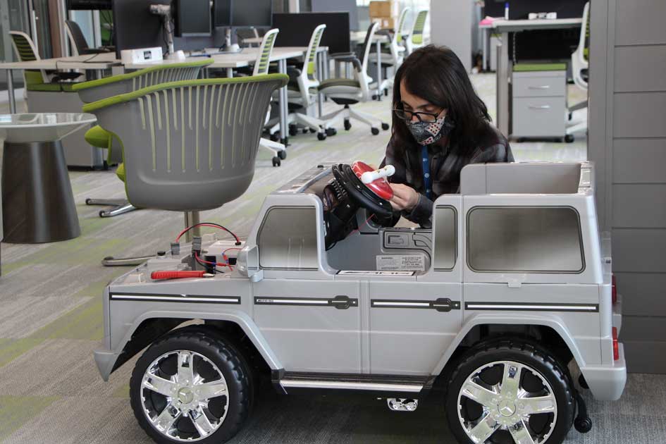 Mark Eisenbraun makes adjustments to modifications made on an electric car being prepared for a South Dakota child.