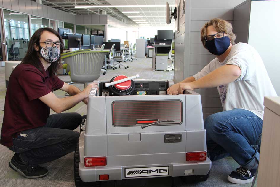 Mark Eisenbraun (left) and Nick Gourley, work on the electric car provided by DSU’s CybHER program. The modified electric car was presented to a South Dakota child, in partnership with LifeScape. 