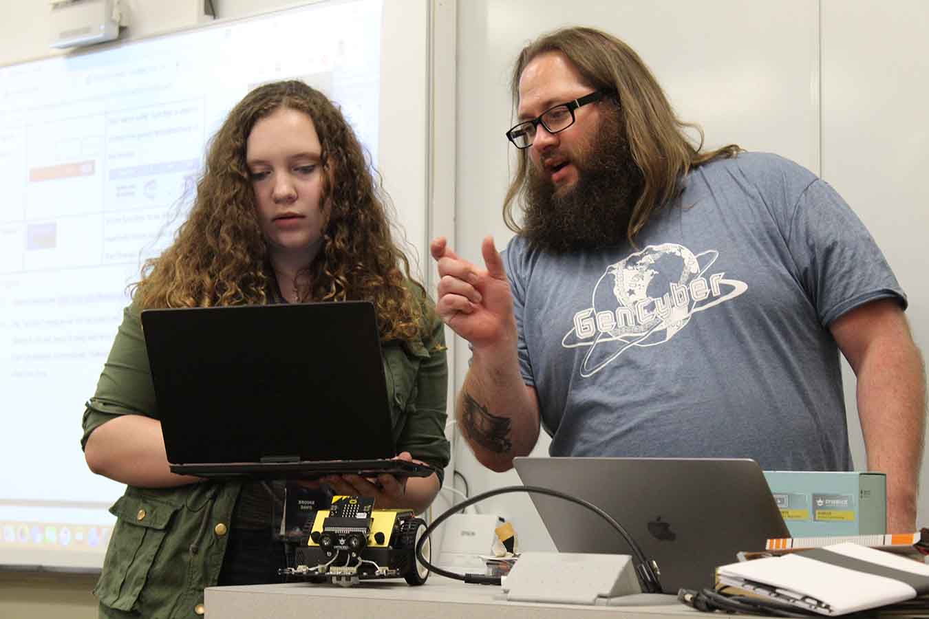 Instructor Rob Honomichl (right) works with a student during GenCyber Camp.