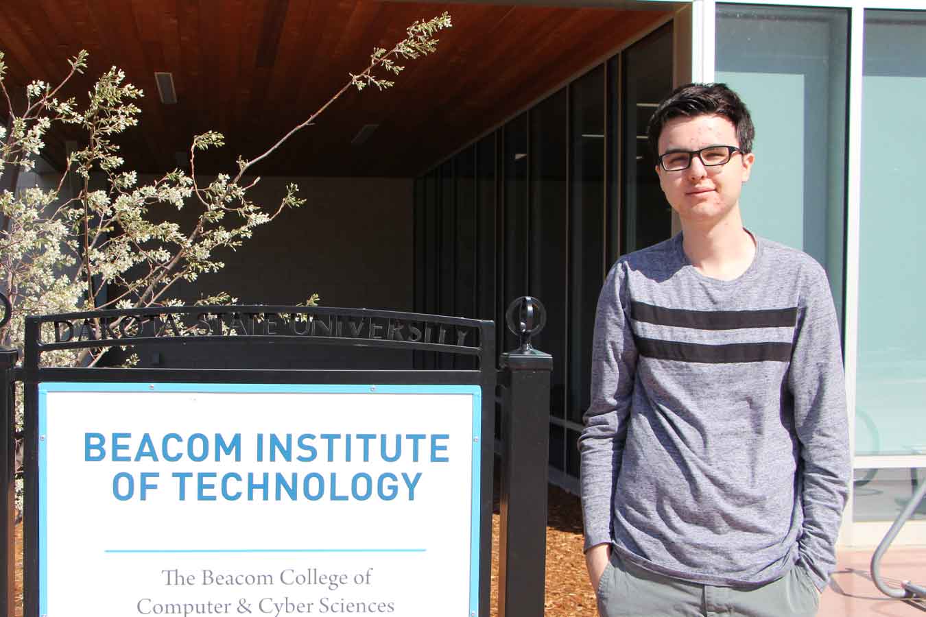 Spencer Sexton standing in front of the Beacom College of computer & Cyber Sciences