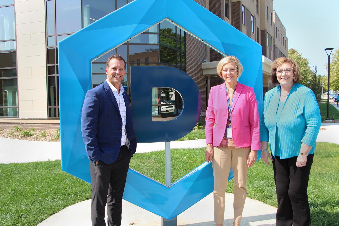 Jon Schemmel, Vice President for Institutional Advancement and CEO of the DSU Foundation and Alumni Association; Tammy Miller, Madison Regional Health System CEO; and President José-Marie Griffiths in front of the Dakota State sculpture.