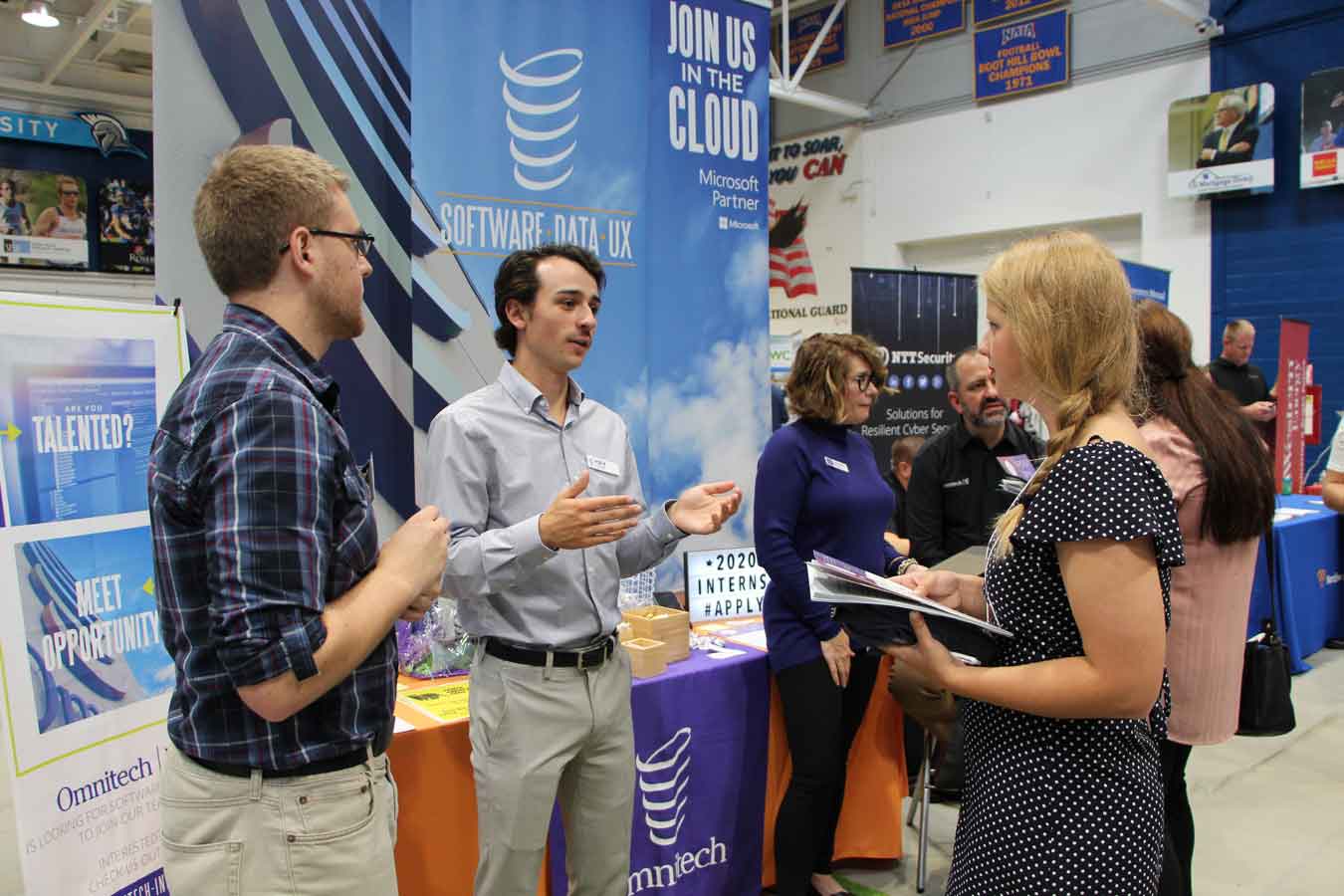 Job Fair at Dakota State. DSU student getting information from employers at their booth.