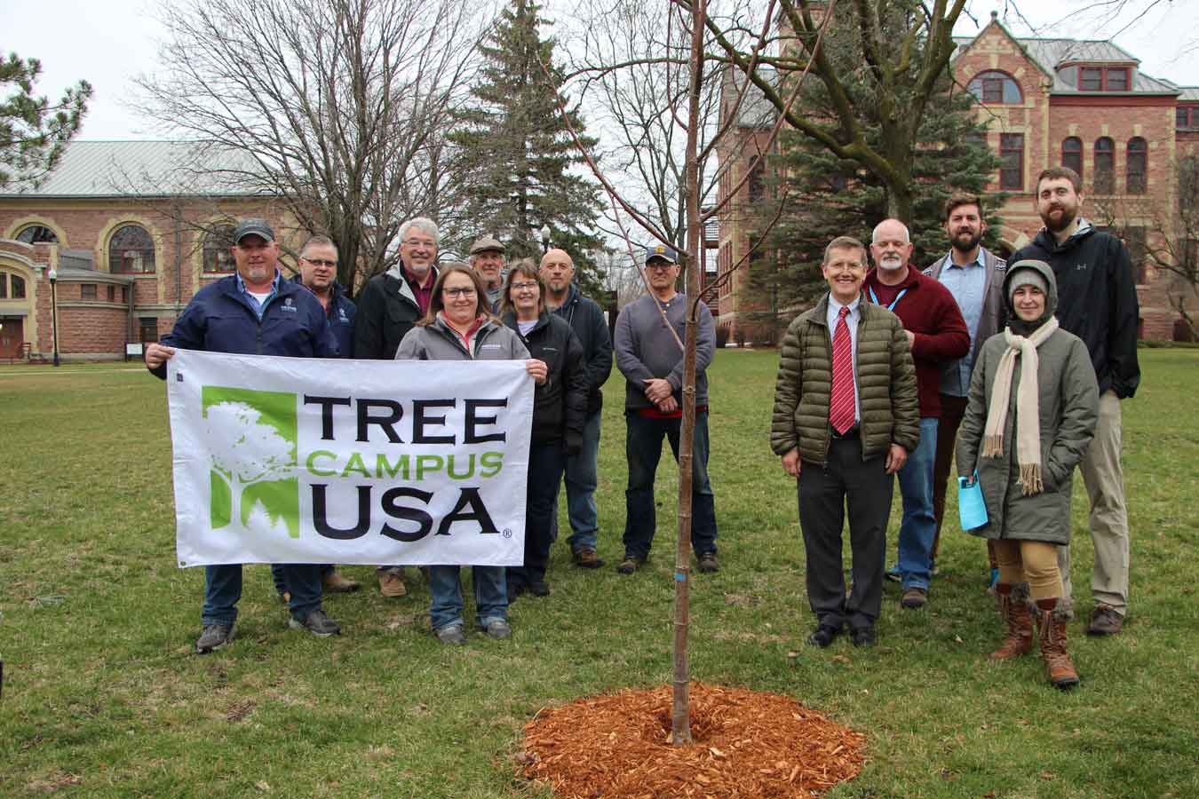 Group of DSU staff and faculty gather to plant a tree on campus.
