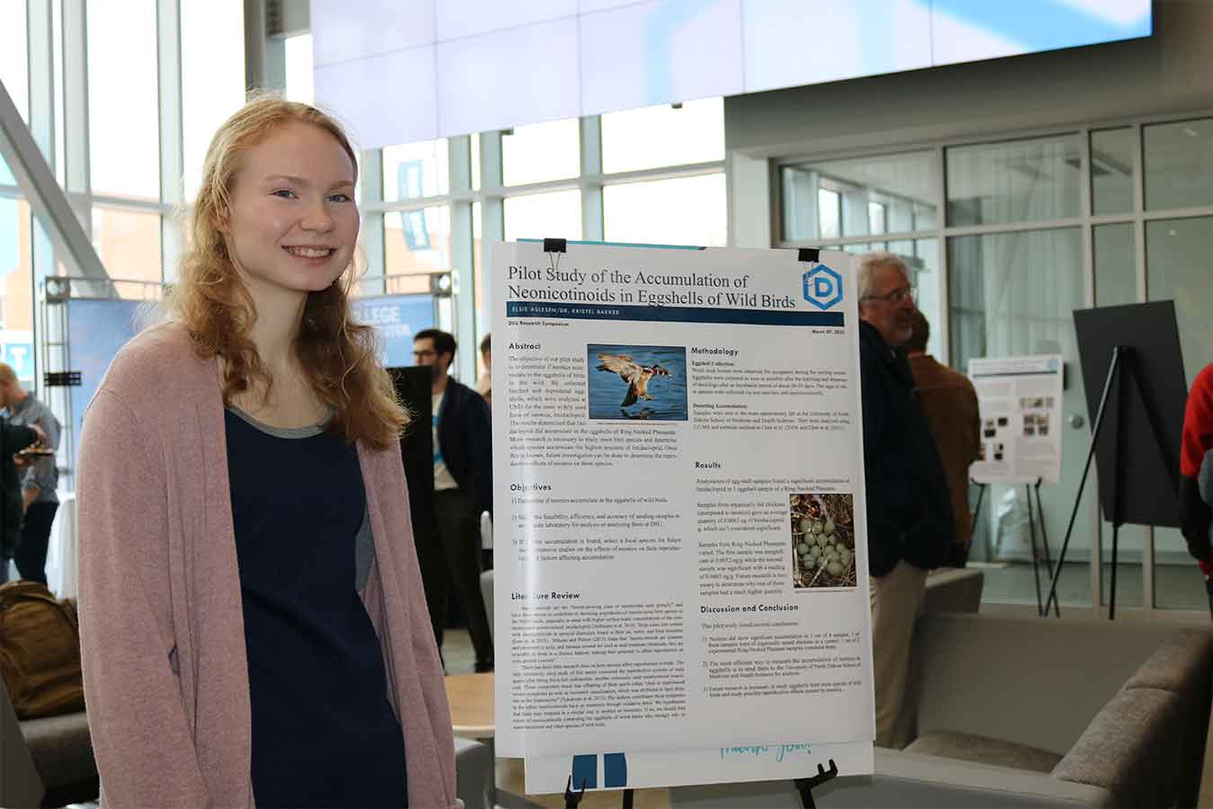 Elsie Aslesen poses for a photo with her research poster from last year's research week