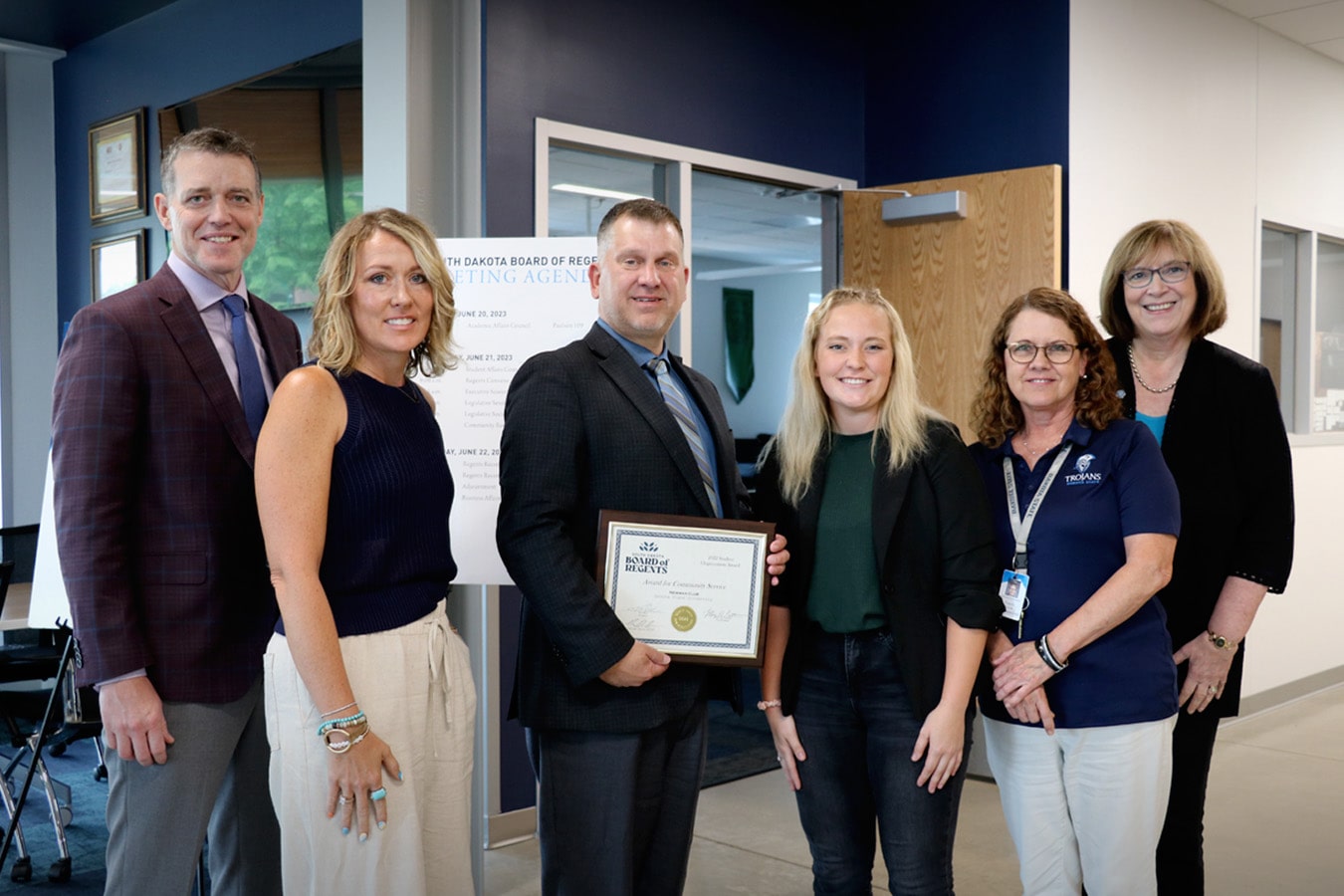 DSU Newman Club member Kelsey O’Connell accepted the BOR Award for Community Service, along with advisors Heidi Comes (left) and Pam Lewis. BOR Executive Director Nathan Lukkes, BOR President Tim Rave, and DSU President José-Marie Griffiths congratulated the group.