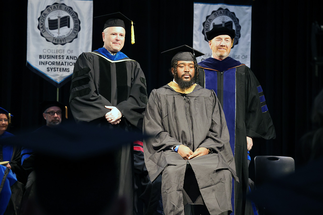 Daidrick Kibbie (center) with Dan Talley (right) and Mark Hawkes (left) at the hooding ceremony after earning his MBA.