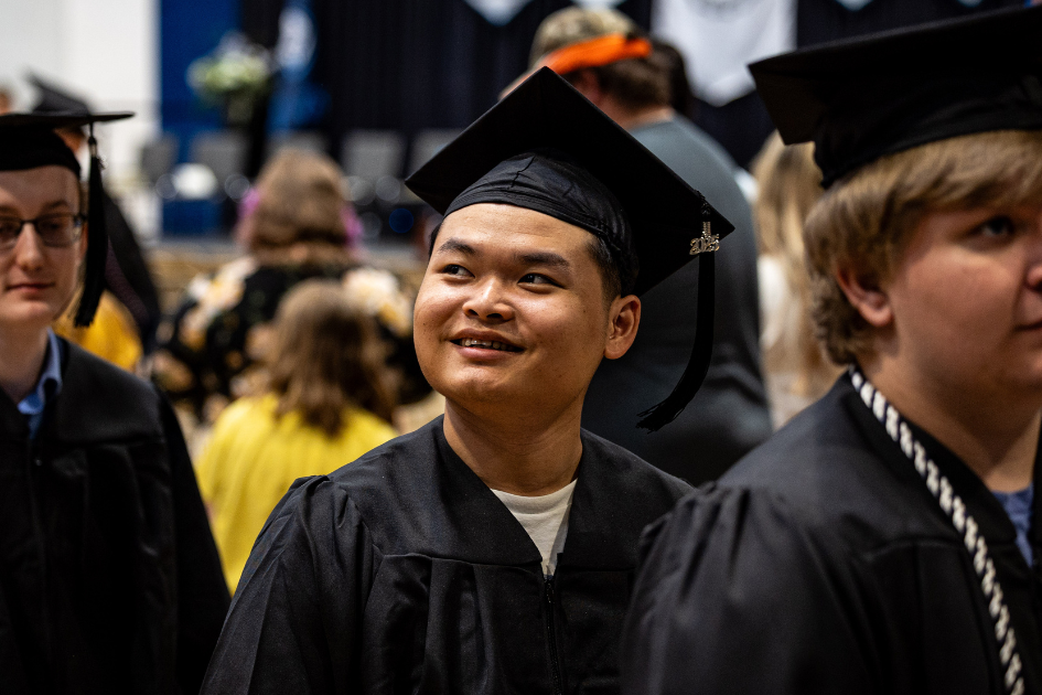 dsu graduate at commencement smiling in cap and gown