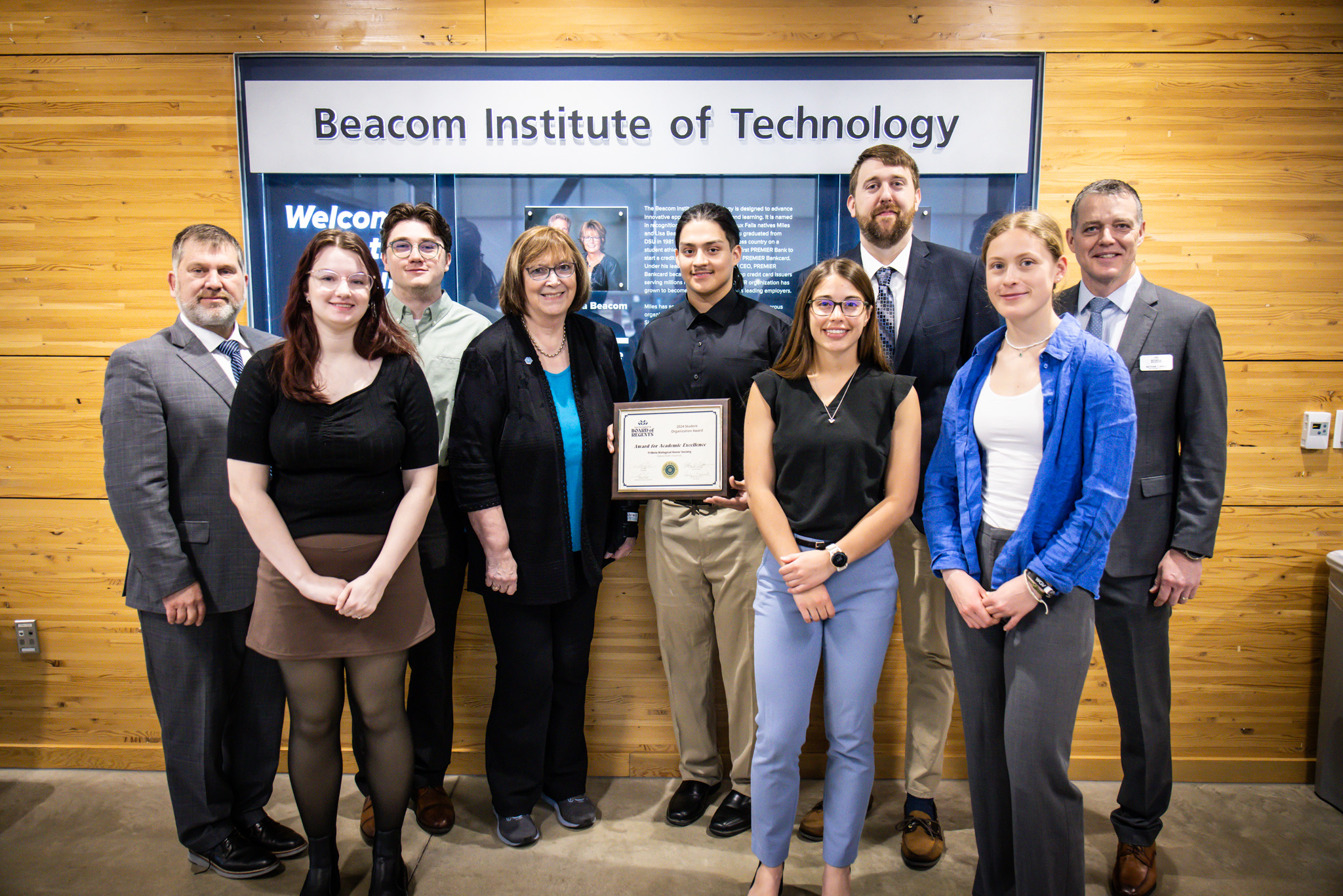 students posing with their award with bor representatives and president griffiths