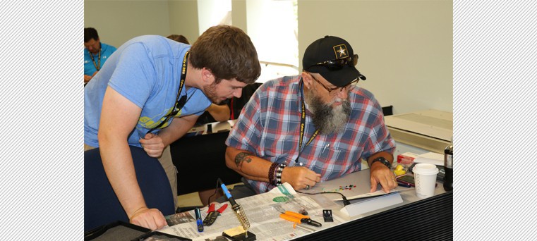 Helping Tucker read a soldering diagram is DSU instructor Andrew Kramer. 