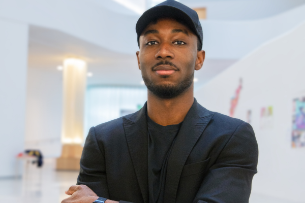 Obatola Layiwola standing in art gallery with arms crossed