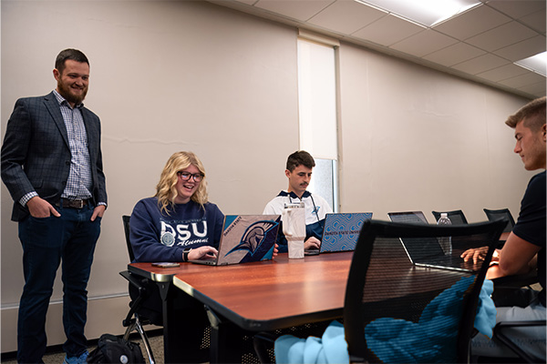 Business analytics students working in a conference room.