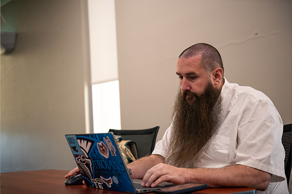 Dakota State university student engaging in project management on a laptop.