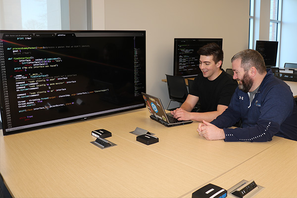 Cyber defense doctoral student consulting with instructor.